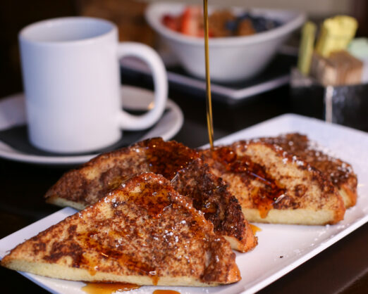 French toast being drizzled with syrup
